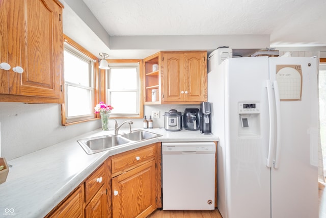 kitchen featuring sink, white appliances, and a textured ceiling