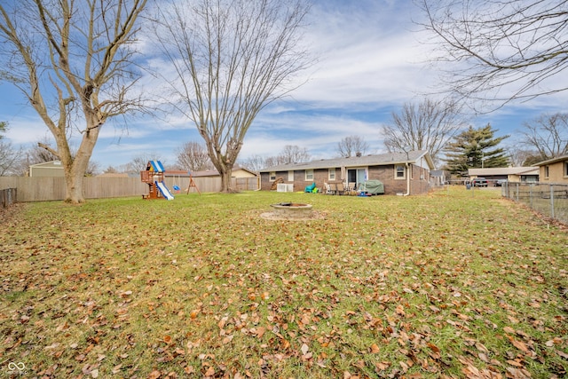 view of yard with a playground and an outdoor fire pit