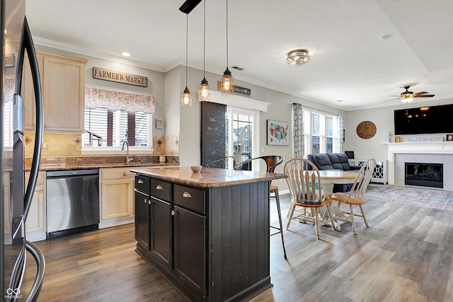 kitchen featuring a center island, black refrigerator, stainless steel dishwasher, pendant lighting, and dark stone counters