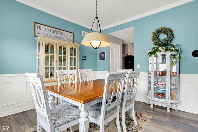 dining room featuring ornamental molding and dark hardwood / wood-style floors