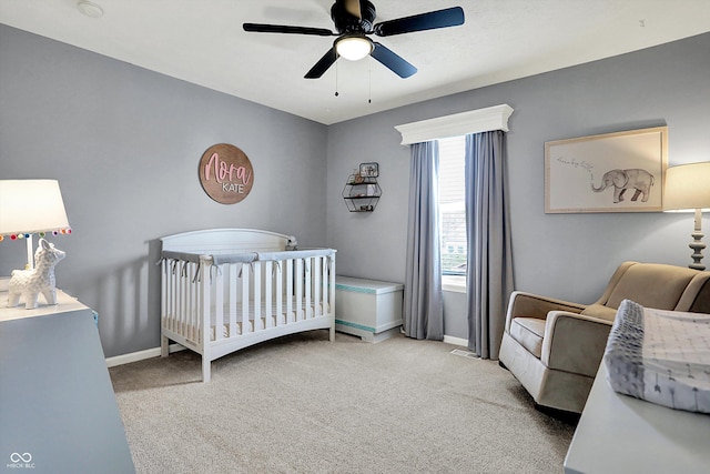 carpeted bedroom with a nursery area and ceiling fan