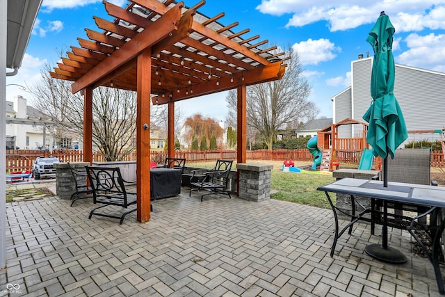 view of patio featuring a playground and a pergola