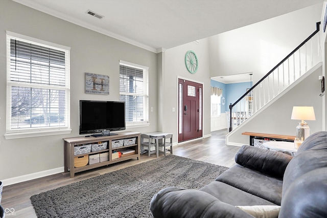 living room with hardwood / wood-style flooring, ornamental molding, and a healthy amount of sunlight