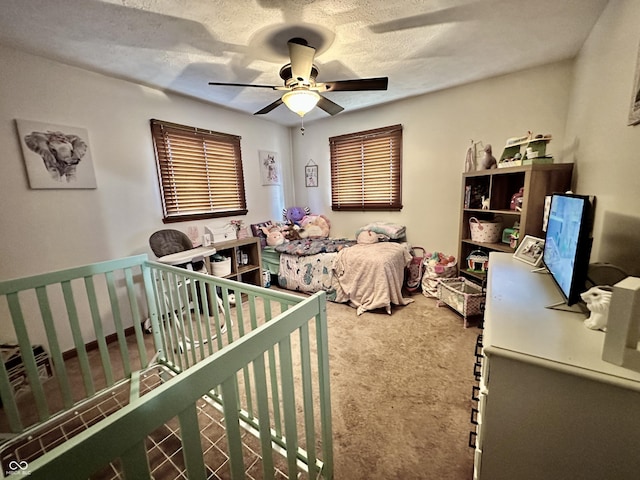 carpeted bedroom featuring ceiling fan and a textured ceiling