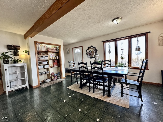 dining space featuring a textured ceiling, built in features, and beamed ceiling