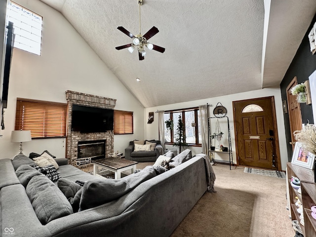 living room with high vaulted ceiling, light colored carpet, ceiling fan, a brick fireplace, and a textured ceiling