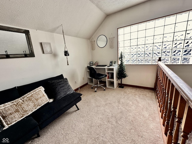 carpeted home office featuring lofted ceiling and a textured ceiling