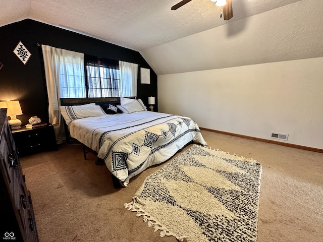 carpeted bedroom featuring vaulted ceiling, ceiling fan, and a textured ceiling