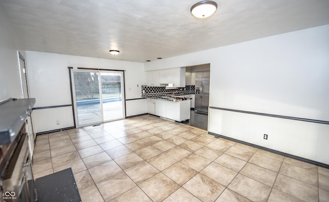 kitchen featuring range hood, white cabinets, backsplash, light tile patterned floors, and stainless steel refrigerator with ice dispenser