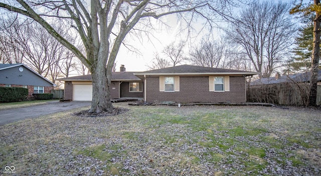 single story home with a garage and a front lawn