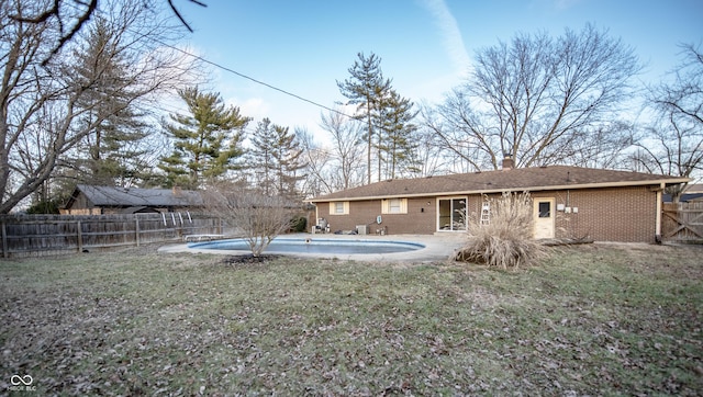 back of property with a fenced in pool, a yard, and a patio area