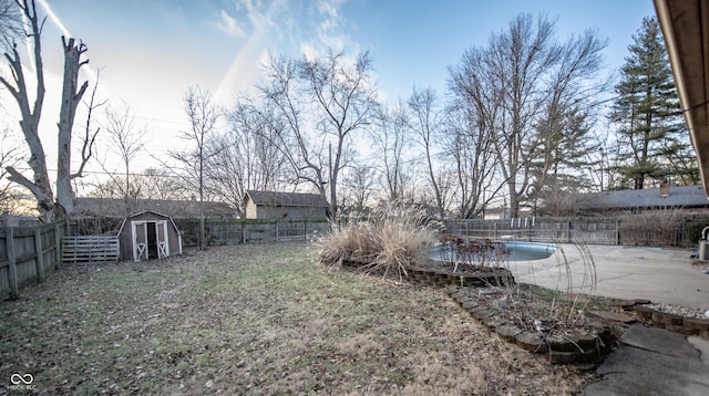 view of yard featuring an empty pool and a shed