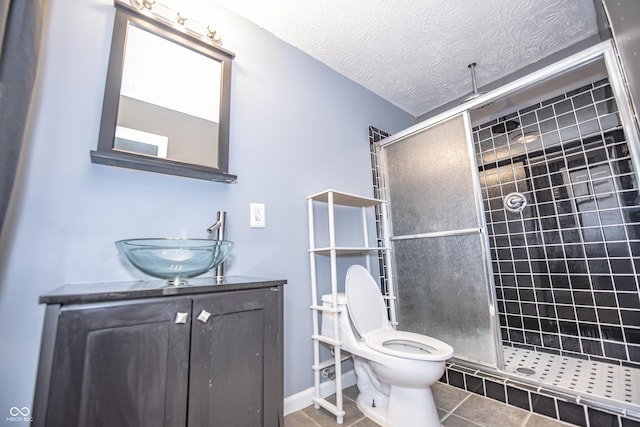 bathroom with vanity, toilet, a textured ceiling, and walk in shower