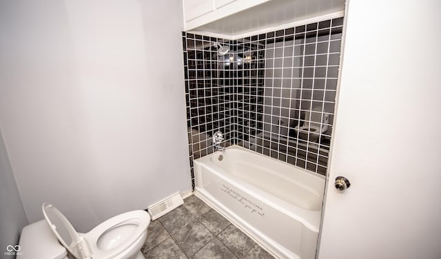 bathroom featuring tiled shower / bath combo, tile patterned floors, and toilet