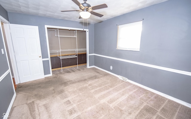 unfurnished bedroom with carpet floors, a closet, and ceiling fan