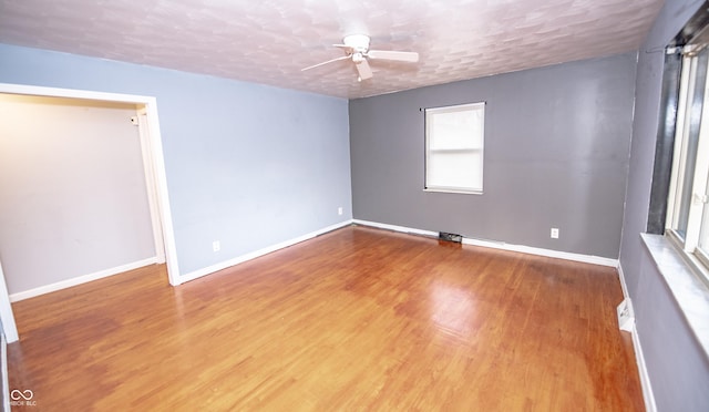 unfurnished room with hardwood / wood-style flooring, ceiling fan, and a textured ceiling