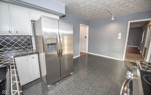 kitchen with a textured ceiling, stainless steel fridge with ice dispenser, decorative backsplash, and white cabinets