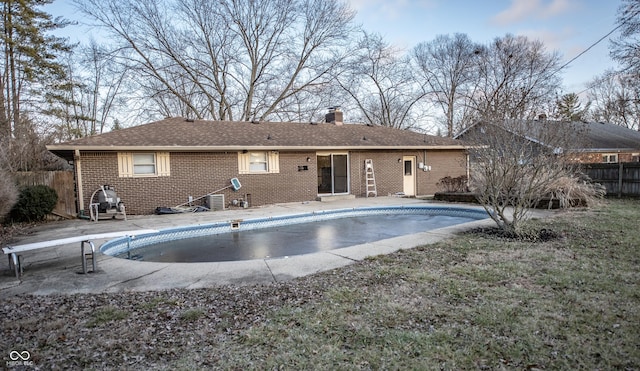 view of pool with a diving board and a patio area