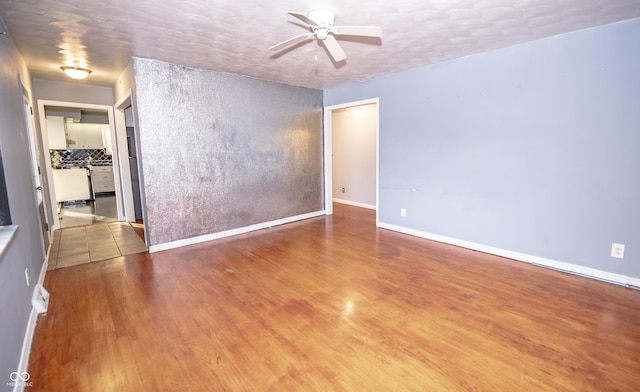 unfurnished room with hardwood / wood-style flooring, a textured ceiling, and ceiling fan