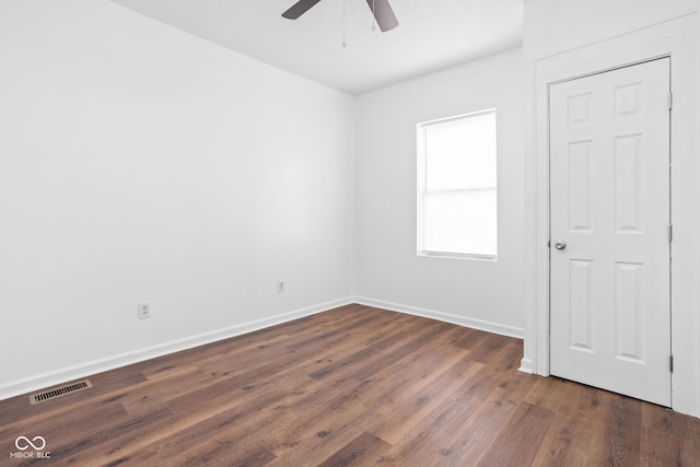 spare room with dark hardwood / wood-style floors and ceiling fan