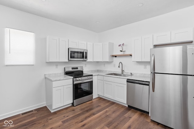 kitchen with white cabinetry, appliances with stainless steel finishes, sink, and dark hardwood / wood-style flooring