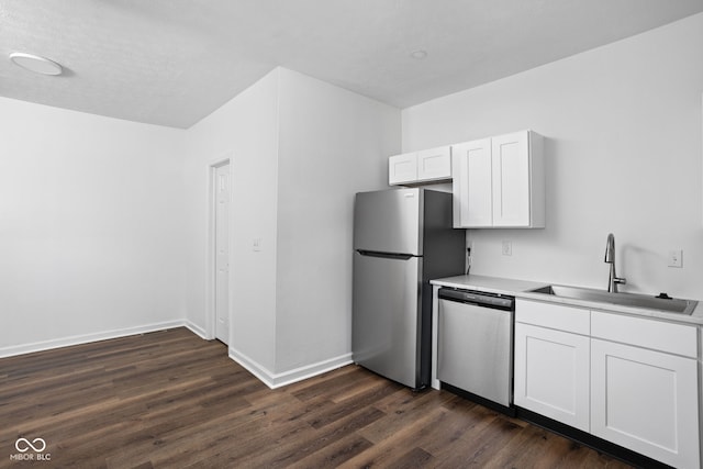 kitchen featuring dark wood-type flooring, appliances with stainless steel finishes, sink, and white cabinets