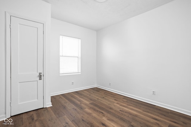 unfurnished room with dark hardwood / wood-style flooring