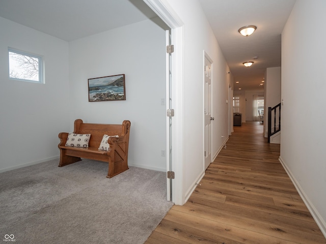 hall featuring light wood-style floors and baseboards