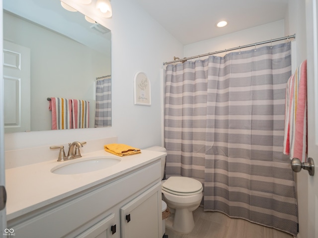 bathroom with recessed lighting, vanity, and toilet