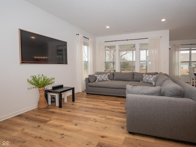 living room featuring light wood-style flooring, baseboards, and recessed lighting