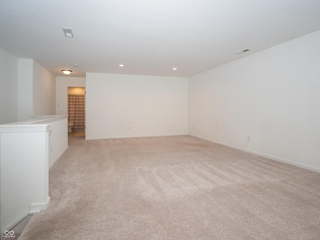 empty room with recessed lighting, light colored carpet, visible vents, and baseboards