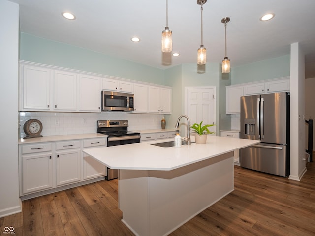 kitchen with stainless steel appliances, white cabinetry, a sink, and backsplash