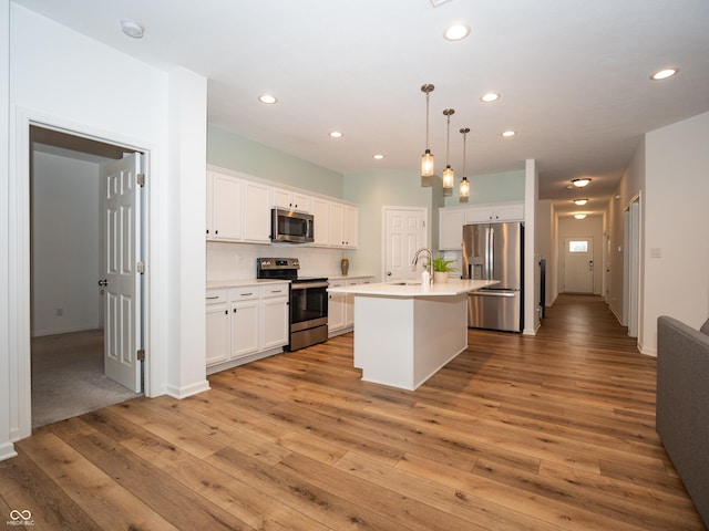 kitchen featuring recessed lighting, white cabinetry, light countertops, appliances with stainless steel finishes, and light wood finished floors