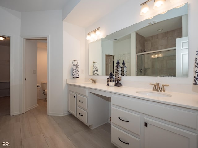 full bathroom with toilet, a sink, visible vents, a shower stall, and double vanity