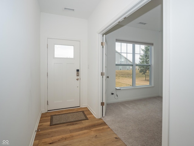 entryway featuring light wood-type flooring, baseboards, and visible vents