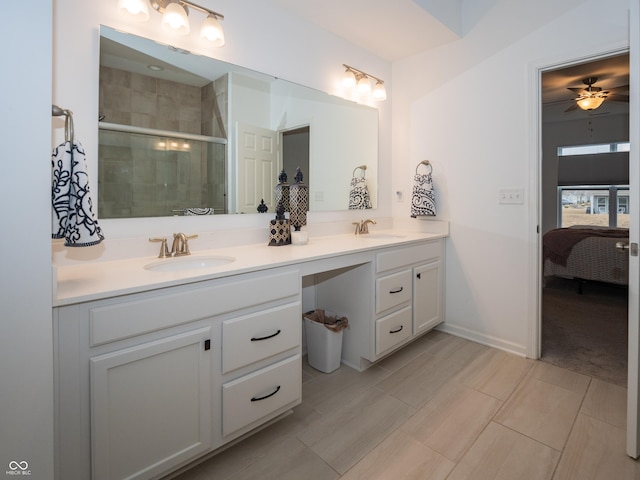 bathroom featuring double vanity, a shower stall, a sink, and ensuite bathroom