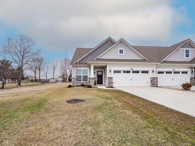 view of front of home featuring stone siding, a front lawn, and concrete driveway