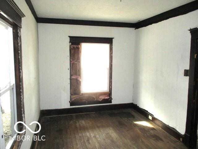 unfurnished room with hardwood / wood-style flooring and crown molding