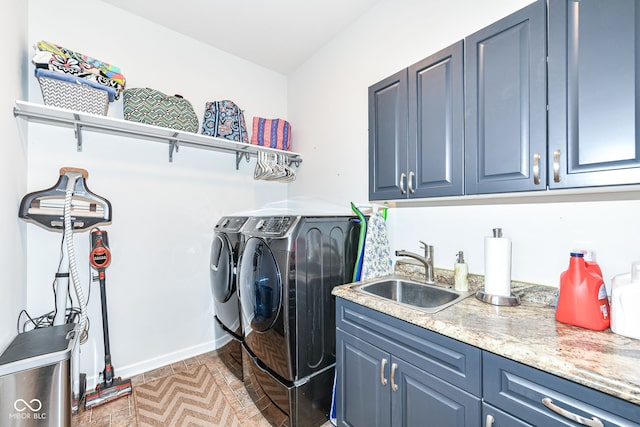 laundry room with sink, washing machine and dryer, and cabinets