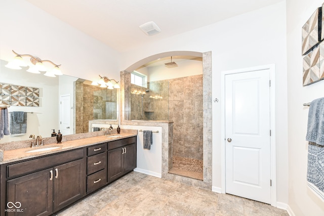 bathroom featuring a tile shower and vanity