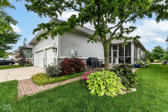 view of side of home with a garage, a sunroom, and a lawn