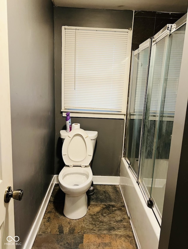 bathroom featuring shower / bath combination with glass door and toilet