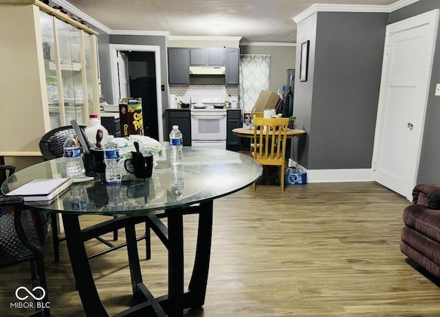 dining room with crown molding and light wood-type flooring