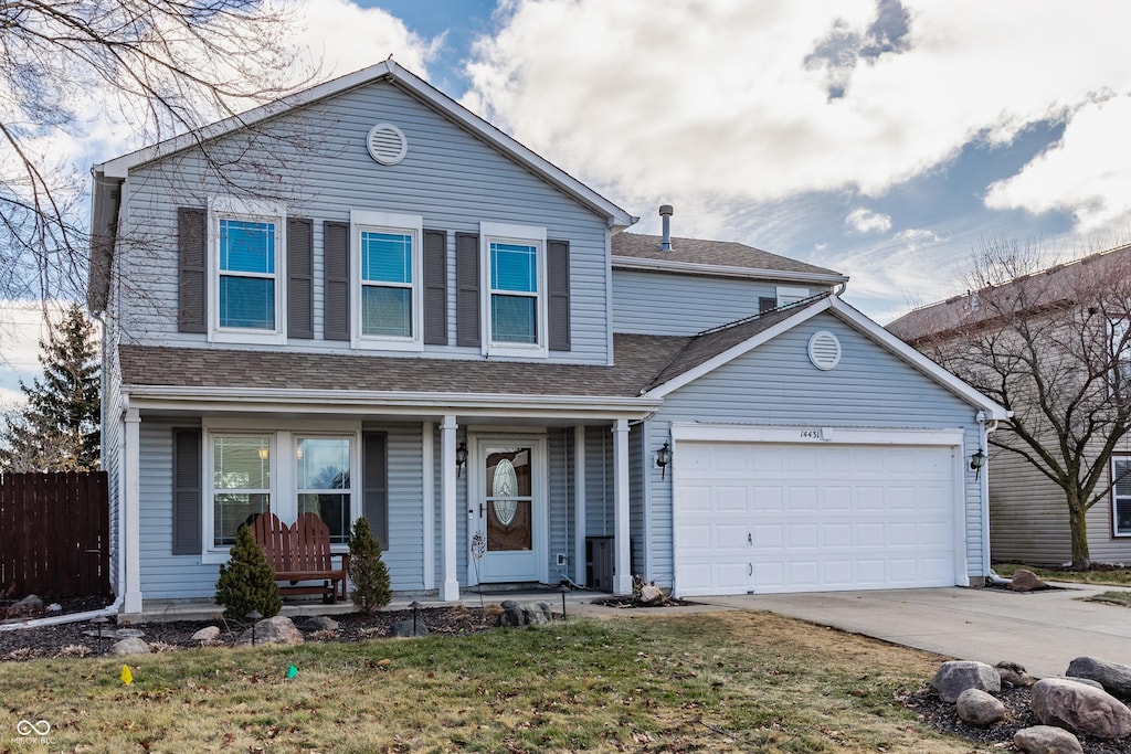 view of property featuring a garage and a front lawn