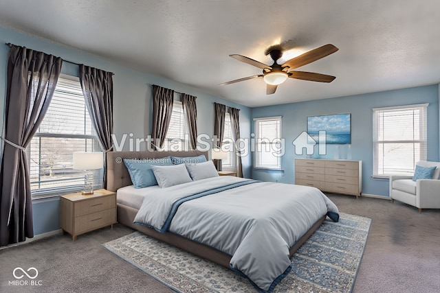 bedroom with ceiling fan, carpet, and a textured ceiling