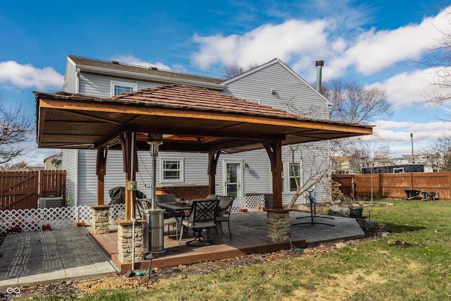 exterior space with cooling unit, a deck, and a lawn