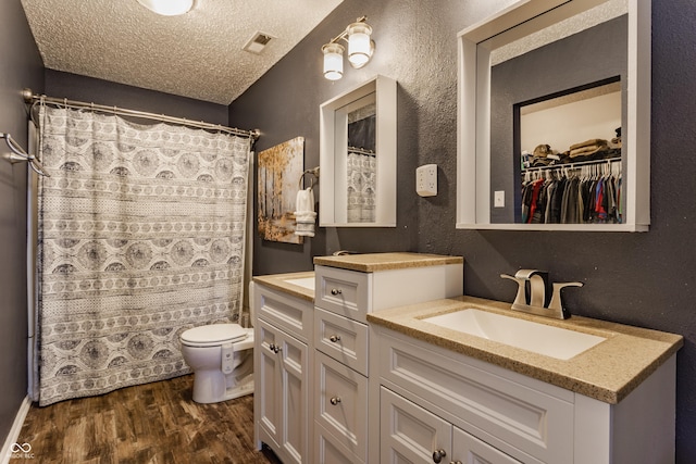 bathroom featuring toilet, a shower with curtain, wood-type flooring, a textured ceiling, and vanity