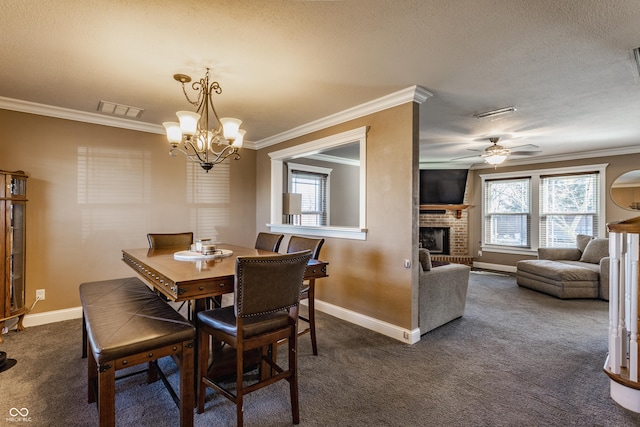 dining area with a brick fireplace, a textured ceiling, ornamental molding, dark carpet, and ceiling fan with notable chandelier