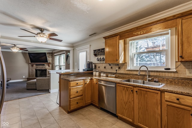 kitchen with a healthy amount of sunlight, sink, dishwasher, and a brick fireplace