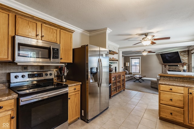 kitchen featuring a textured ceiling, a brick fireplace, ornamental molding, stainless steel appliances, and backsplash